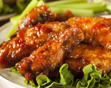 A plate of glazed and sauced chicken wings.