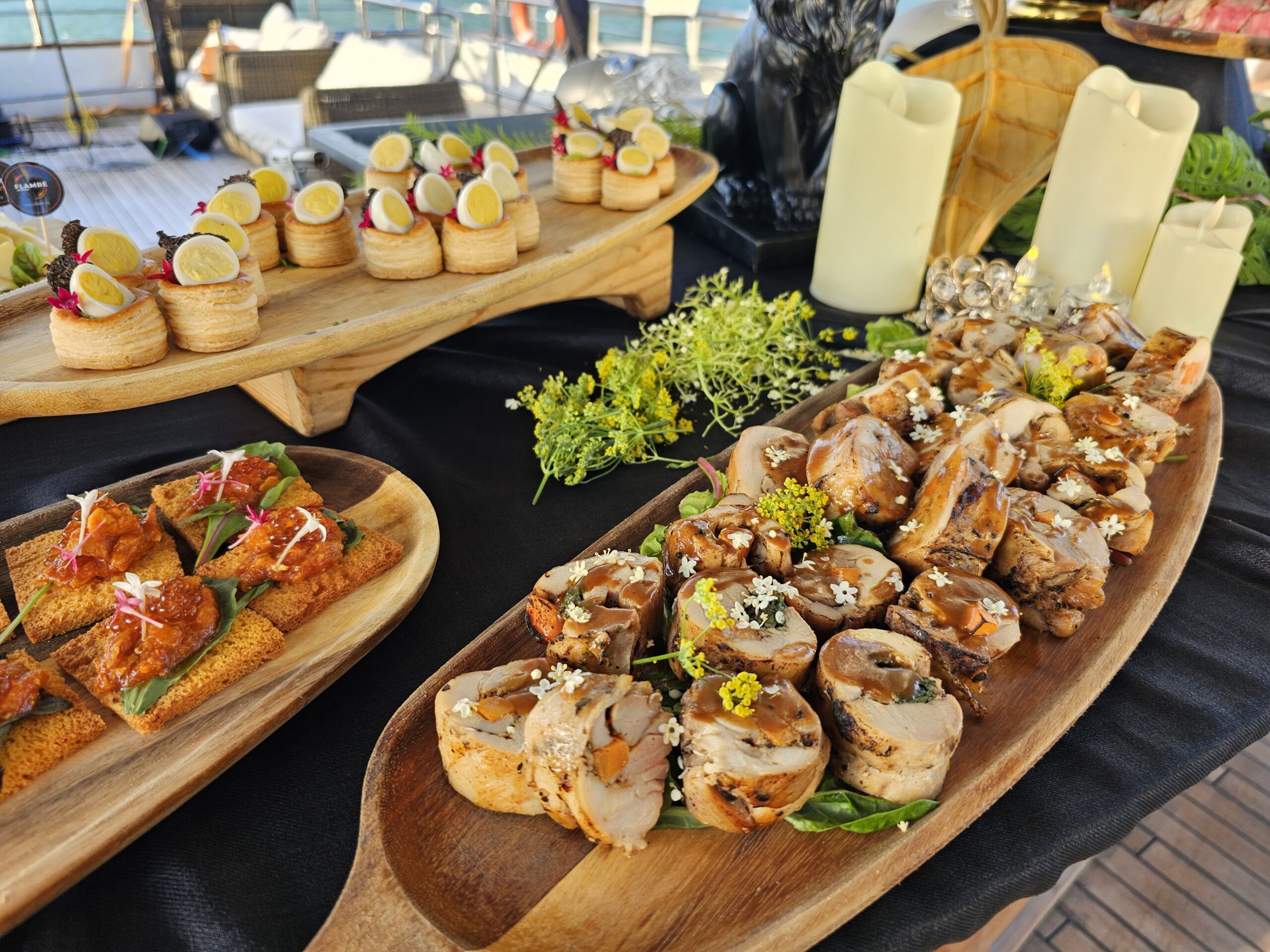 Display of gourmet rolled chicken, quail egg canapés, and savory crostini.